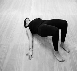 women in exercise gear lying on floor with back arched
