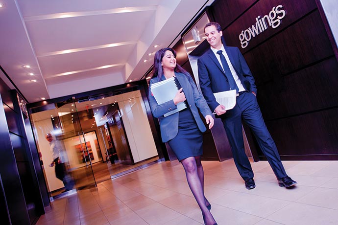 Man and woman walking down hallway in front of Gowlings