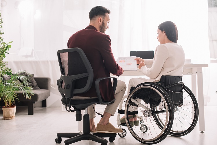 man in chair next to woman in wheelchair