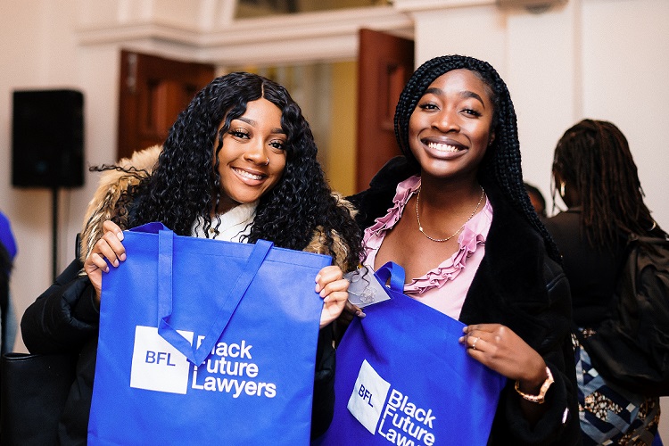 Two black women holding blue Black Future Lawyer bag