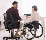 man in chair next to woman in wheelchair