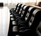 Row of padded chairs at a board table