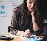 Lady at desk looking down at financial papers