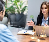 Woman lawyer sitting at a desk advising a male client