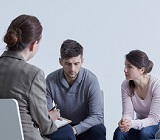 Three people sitting in circle in a support group