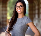 Young lady standing confidently holding tablet