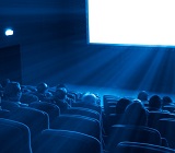 blue-toned photo of audience in movie theatre watching screen