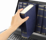 A hand reaching into a laptop monitor and pulling out a book