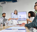 four professionals, of diverse races and ages, discuss business over meeting table