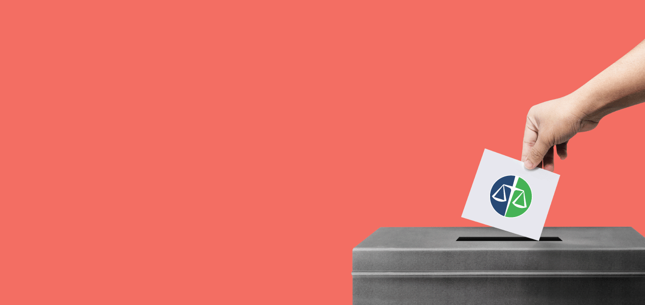 Hand placing a ballot into a voting box